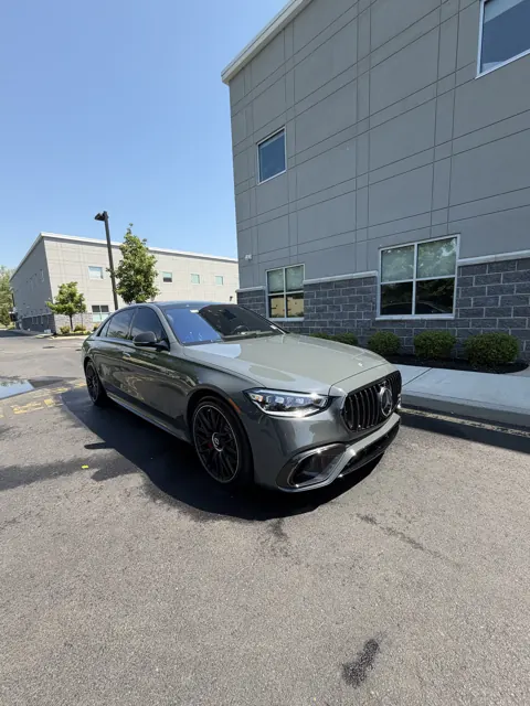 Dark sedan viewed from the front in a driveway