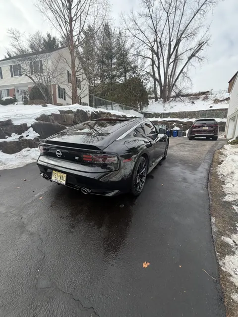 Dark sedan front grille and hood on a winter street