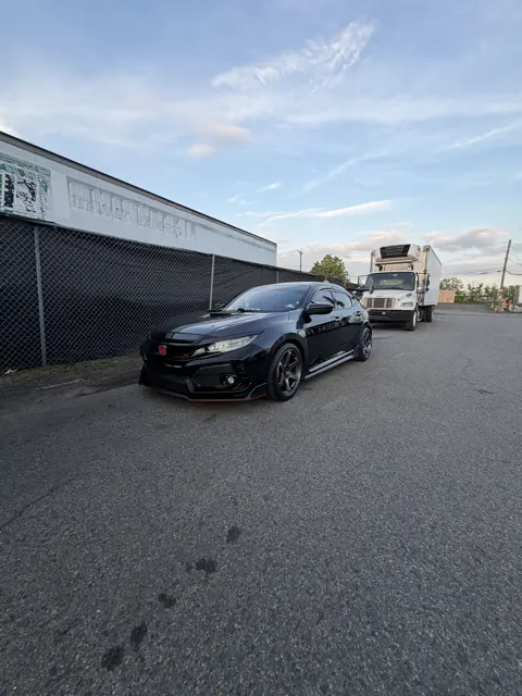 Dark sedan parked beside an industrial building