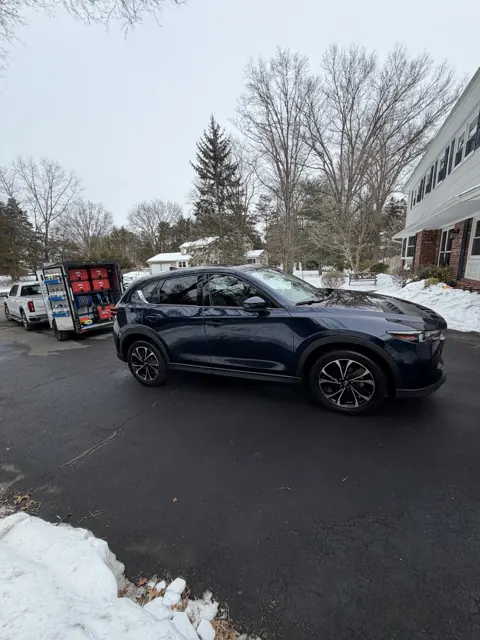 Dark sedan shown in profile outdoors