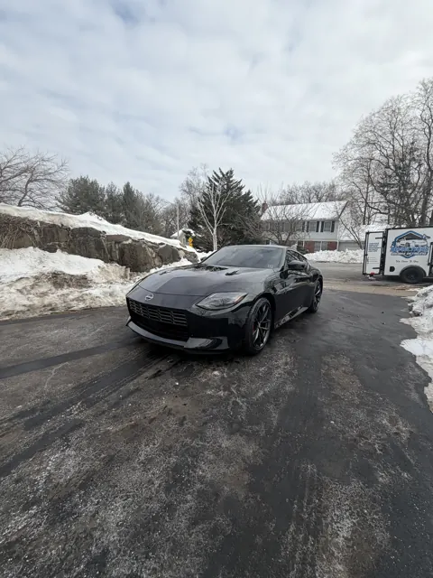 Dark sedan on a residential street in winter