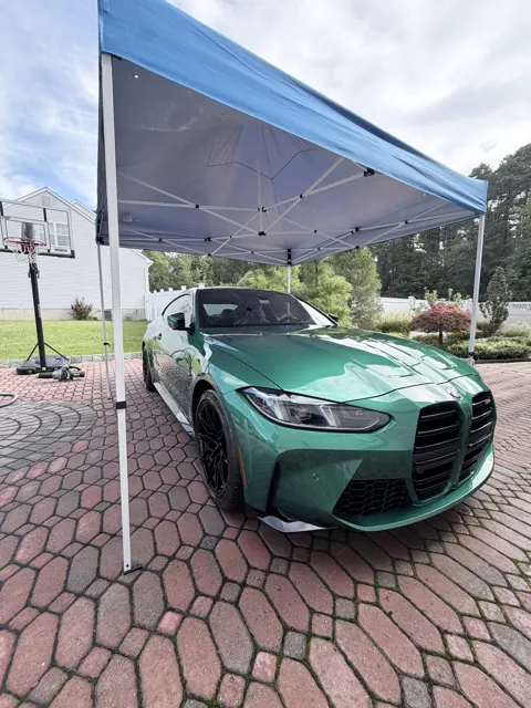 Green coupe parked under the mobile detailing canopy