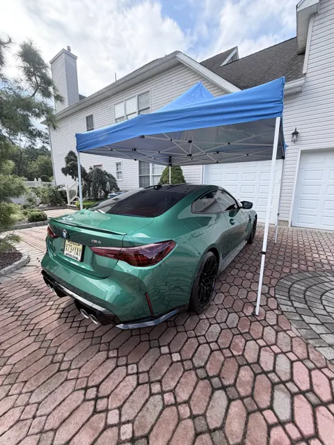Green coupe viewed from the rear beside the detailing setup