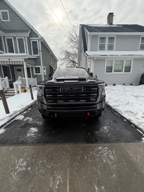 Front grille and hood of a dark pickup truck