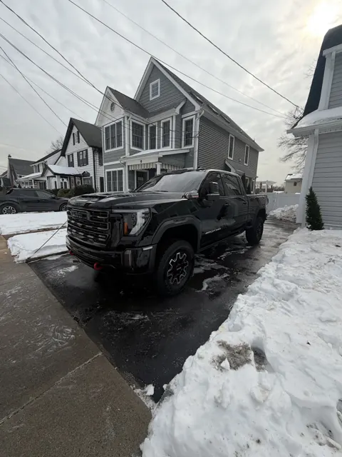 Dark pickup truck viewed from the rear in a driveway
