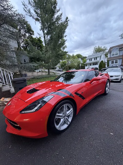 Red sports car viewed from the front on a residential street