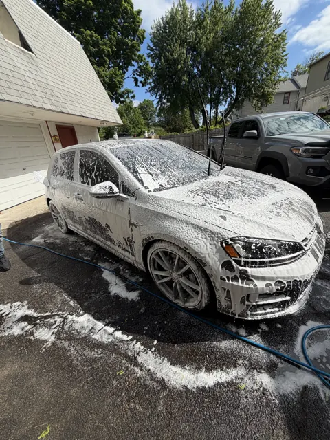 Silver hatchback covered in wash foam